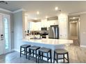 This modern kitchen features a large island with bar seating, sleek countertops, and stainless steel appliances at 16126 San Donato Pl, Bradenton, FL 34211