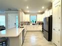 Bright kitchen featuring white cabinets, stainless steel appliances, and sleek tile flooring at 16126 San Donato Pl, Bradenton, FL 34211