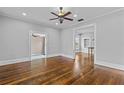 Spacious living room featuring hardwood floors, a ceiling fan, and open doorways leading to other rooms at 204 W Calhoun St, Plant City, FL 33563