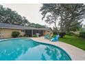 Backyard oasis with a refreshing pool, screened in porch, and inviting outdoor seating area at 2273 Willowbrook Dr, Clearwater, FL 33764