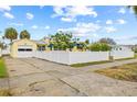 A yellow home with white trim and a matching white fence and a driveway to the garage at 260 42Nd Ave, St Pete Beach, FL 33706