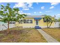 Charming yellow home featuring a well-maintained lawn and mature landscaping at 260 42Nd Ave, St Pete Beach, FL 33706
