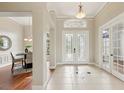 Welcoming foyer features decorative tile flooring, elegant lighting, and glass-paneled doors at 2708 Coastal Range Way, Lutz, FL 33559