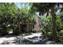 Home with brick chimney surrounded by lush trees, providing shade and privacy at 272 Orange St, Palm Harbor, FL 34683