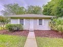Cozy one-story home with white trim, well-maintained lawn, and a welcoming walkway at 27511 Hialeah Way, Wesley Chapel, FL 33544
