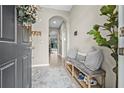 View of entryway with ceramic tile flooring, coat rack with bench, gray pillows and decorative touches at 2771 Suncoast Blend Dr, Odessa, FL 33556