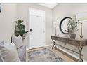 View of entryway with ceramic tile flooring, coat rack with bench, gray pillows and decorative touches at 2771 Suncoast Blend Dr, Odessa, FL 33556