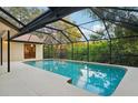 Enclosed pool area featuring a spacious patio, refreshing pool, and serene backyard views at 2990 Longbrooke Way, Clearwater, FL 33760