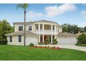 Charming two-story home with manicured front lawn and mature landscaping, including a palm tree at 3062 Sutton Woods Dr, Plant City, FL 33566