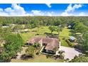 Expansive aerial view of the property showcasing the house, surrounding greenery, and private pond at 3452 Forelock Rd, Tarpon Springs, FL 34688