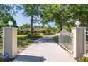 Grand entrance with stately pillars, an elegant gate, and a long driveway leading to the impressive home at 3452 Forelock Rd, Tarpon Springs, FL 34688