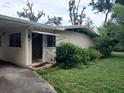 Charming home exterior with a covered entryway and lush, mature landscaping at 503 Sunset Rd, Plant City, FL 33563