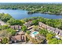 Aerial view of the condos with a pool and lake view surrounded by lush greenery at 5122 Puritan Cir # 5122, Tampa, FL 33617