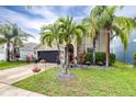 Charming two-story home with a well-maintained lawn and landscaping featuring palm trees and flowering plants at 533 Vista Ridge Dr, Ruskin, FL 33570