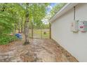 Serene backyard space featuring a gate leading to a large lot surrounded by lush green trees and natural landscape at 5422 Wilkins Trl, Brooksville, FL 34602