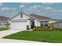 Beautiful single-story home boasts lush landscaping, a two-car garage, and a clean, modern design at 5687 Barakat Rd, Zephyrhills, FL 33541