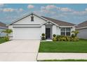 Beautiful single-Gathering home boasting an attached two-car garage, and an attractive, landscaped front yard at 5687 Barakat Rd, Zephyrhills, FL 33541