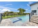 Backyard swimming pool and hot tub with a fenced in yard for privacy and steps to the main house at 6528 Simone Shores Cir, Apollo Beach, FL 33572