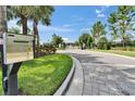 Community entrance gate with a call box, lush landscaping and paver walkway at 6658 Devlin Ln, Wesley Chapel, FL 33545