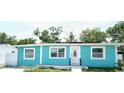 Charming turquoise single-story home featuring bright trim, updated windows, and solar panels at 7510 N Tampania Ave, Tampa, FL 33614