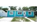 Turquoise single-story home with white trim, updated windows and lawn at 7510 N Tampania Ave, Tampa, FL 33614