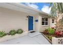 Inviting front entrance with a bright blue door, desert landscaping, and freshly painted exterior at 821 52Nd S Ave, St Petersburg, FL 33705