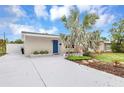 Inviting single-story home with a new driveway, desert landscaping, and a vibrant blue front door at 821 52Nd S Ave, St Petersburg, FL 33705