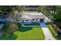 An aerial view of a meticulously maintained single-story house with a lush lawn and a paved driveway at 8444 15Th N Way, St Petersburg, FL 33702