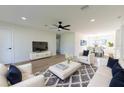 An open-concept living room featuring modern decor, white furnishings, wood flooring, and lots of light at 8444 15Th N Way, St Petersburg, FL 33702