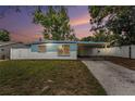Charming single-story home featuring a covered carport and a well-maintained front yard with a white picket fence at 8556 91St Ter, Seminole, FL 33777
