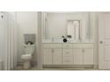 Bathroom boasting a dual sink vanity, framed mirror, white toilet, and shower with white shower curtain at 9604 Runaway Breeze Dr, Land O Lakes, FL 34637