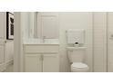 Bathroom featuring a toilet, undermounted sink with vanity, framed mirror, and subway tiled shower at 9604 Runaway Breeze Dr, Land O Lakes, FL 34637