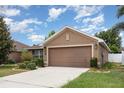 A well maintained single story home with a two car garage and a long driveway at 10847 Kirkwall Port Dr, Wimauma, FL 33598