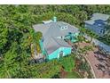 Aerial view of vibrant, beautifully landscaped home with a brick driveway at 1217 N Florida Ave, Tarpon Springs, FL 34689