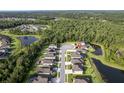 Aerial view of homes in a neighborhood with ponds and wooded areas, property marked with a red pin at 12593 Retreat Pl, Spring Hill, FL 34610