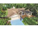Overhead view of a home featuring a well-manicured lawn and a blue driveway at 13094 Huntington Woods Ave, Spring Hill, FL 34609