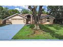 Inviting single-story home with mature trees and a well-manicured lawn at 13094 Huntington Woods Ave, Spring Hill, FL 34609