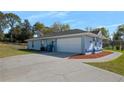 Spacious garage with ample parking space and a long driveway, surrounded by mature trees at 13377 Elise Ln, Spring Hill, FL 34609