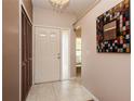 Inviting foyer with tile flooring, coat closet and a decorative mirror creating an open and welcoming entrance at 1617 Dawnridge Ct, Brandon, FL 33510