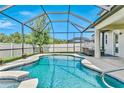 Inviting screened-in pool area with a clear blue pool, comfortable seating, and lush greenery at 18696 Malinche Loop, Spring Hill, FL 34610