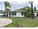 Inviting single-story home with well-maintained landscaping and beautiful mature palm trees at 2470 Del Rio Way, Dunedin, FL 34698