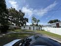 Street view of a cozy home with mature trees and a colorful front door at 2524 Novus St, Sarasota, FL 34237