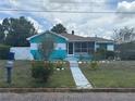 Charming home featuring a screened-in porch and well-manicured front yard at 2701 W Cherry St, Tampa, FL 33607