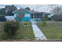 Well-maintained front yard leads to a cozy home with a screened porch at 2701 W Cherry St, Tampa, FL 33607
