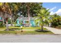 Charming home with a well-kept lawn, brick driveway, lush landscaping, and a welcoming front porch at 2709 Upton S St, Gulfport, FL 33711