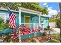 View of the inviting front porch, adorned with an American flag and lush plants at 2709 Upton S St, Gulfport, FL 33711
