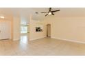 A bright living room features tile floors and an open floor plan leading to the kitchen at 2718 Chipley Ave, North Port, FL 34286