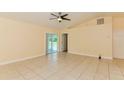 Open living room featuring tile flooring, neutral paint, and sliding doors to screened porch at 2718 Chipley Ave, North Port, FL 34286