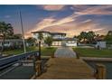 Beautiful waterfront home with lush landscaping, a private dock, and a gray paver driveway at 319 Midway Is, Clearwater Beach, FL 33767
