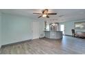 Open living area with wood-look flooring, ceiling fan, and access to kitchen at 3619 15Th Se Ave, Largo, FL 33771